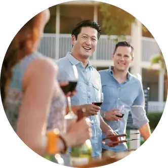 Group of 3 people holding wine glasses and smiling
