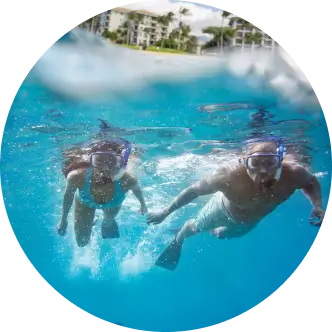 Couple holding hands while snorkeling in turquoise blue water