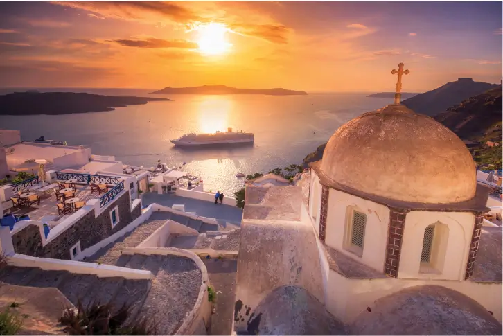 A stunning sunset view over Santorini, Greece, featuring a church dome and a cruise ship in the distance.